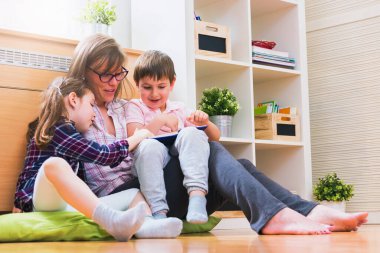 Annem evdeki çocuklara kitap okuyor.