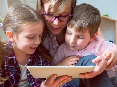 Tablet bilgisayar kullanan iki çocuklu anne.