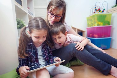 Tablet bilgisayar kullanan iki çocuklu anne.