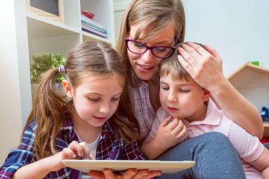 Tablet bilgisayar kullanan iki çocuklu anne.