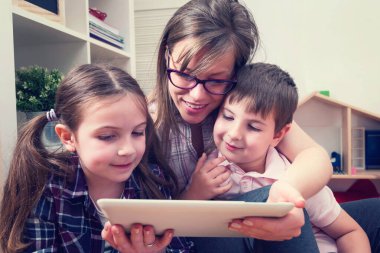 Tablet bilgisayar kullanan iki çocuklu anne.
