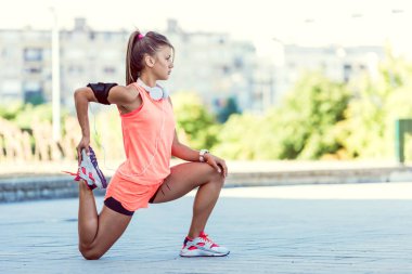 Atletik kız parkta koşuyor.