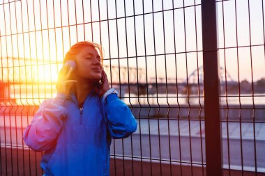 Genç bayan koşucu dinleniyor Nehir kenarında müzik dinliyor