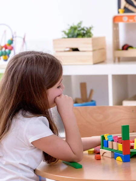 美しい女の子は家でおもちゃのブロックで遊ぶ — ストック写真