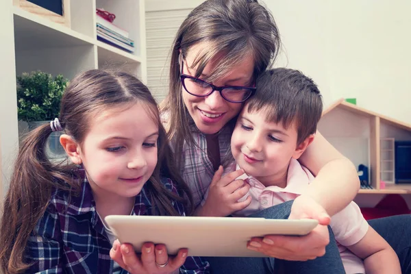 Tablet bilgisayar kullanan iki çocuklu anne.