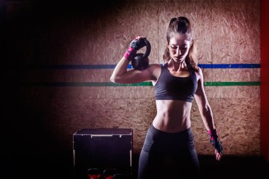 Çekici, genç, formda bir sporcu. Spor salonunda çalışıyor.