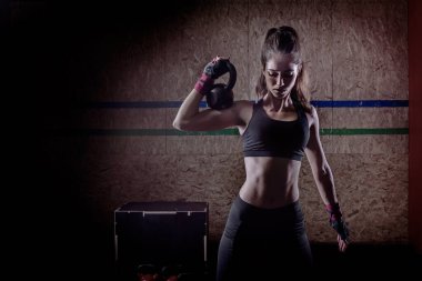 Çekici, genç, formda bir sporcu. Spor salonunda çalışıyor.