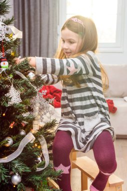 güzel küçük bir kız Noel ağacı süsleme