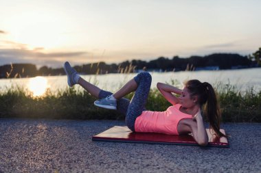 Kumsalda genç kadının yapması germe egzersizleri