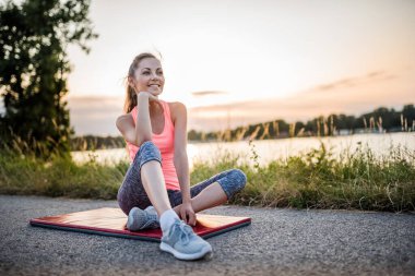 Nehir kenarında oturan genç kadın 