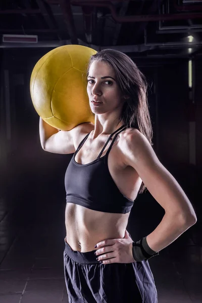 フィットネススポーツの女性は屋内で柔らかい薬ボールを保持します — ストック写真