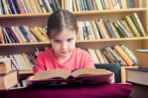Küçük Kız Kütüphanede Kitap Okuyor — Stok fotoğraf