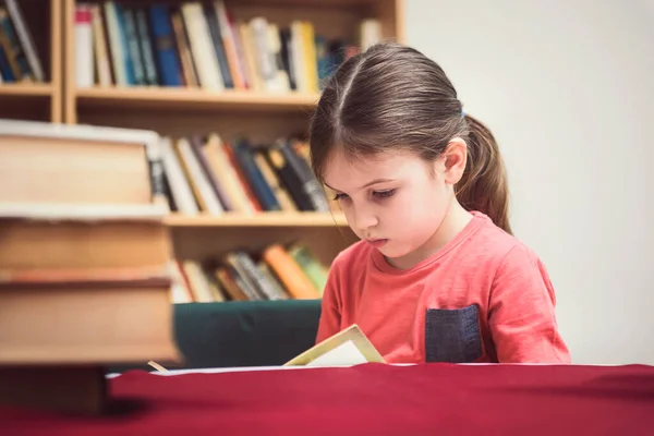 Μικρό Κορίτσι Διαβάζει Βιβλίο Στη Βιβλιοθήκη — Φωτογραφία Αρχείου