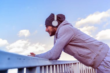 Erkek koşucu yoğun eğitimden sonra ara veriyor, müzik dinliyor. 