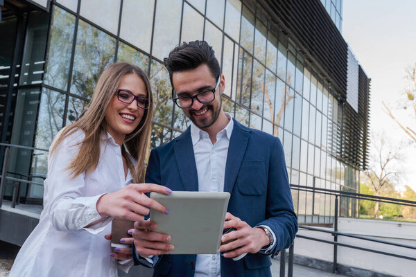 Smiling business couple outdoors in the street on coffee break