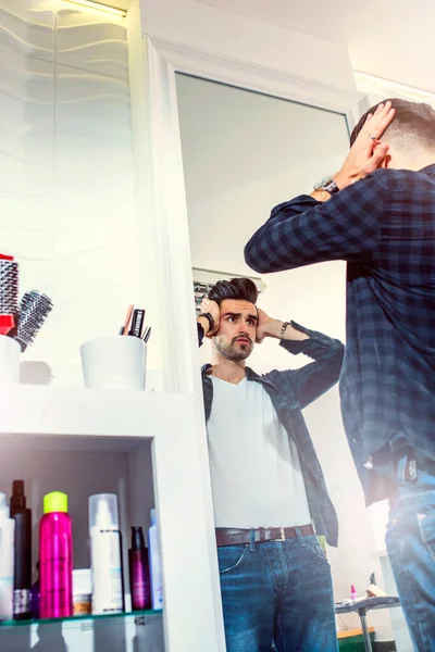 时尚美容师沙龙的帅哥站在镜子前看着自己 刮胡子后皮肤不适 — 图库照片