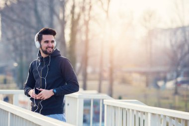 Kulaklıklı Koşan Adam Akıllı Telefon ve Dinleyen Müzik Kullanıyor