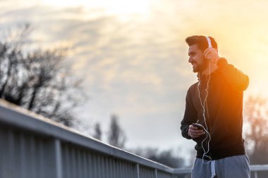 Kulaklıklı Koşan Adam Akıllı Telefon ve Dinleyen Müzik Kullanıyor