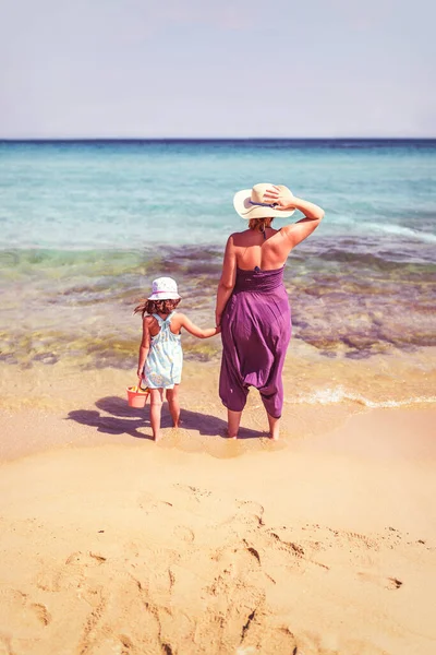 一个母女站在完美翡翠沙滩上的背景图 — 图库照片