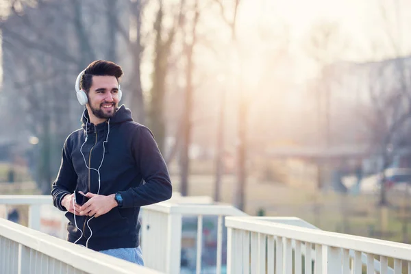 Man Jogger Ακουστικά Χρησιμοποιώντας Smartphone Και Ακρόαση Μουσική — Φωτογραφία Αρχείου