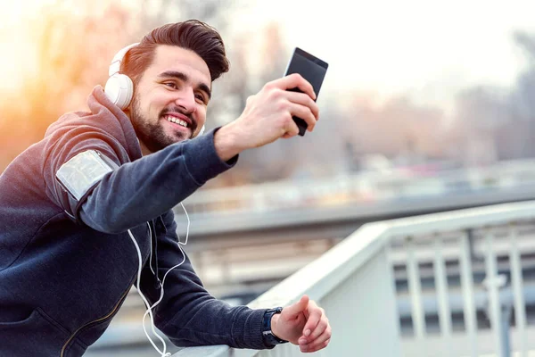 stock image Urban jogging man taking brake taking selfie with his smart phone