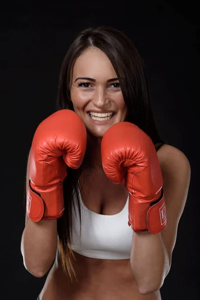 黒を背景に赤いボクシングの手袋をした若い女性 — ストック写真