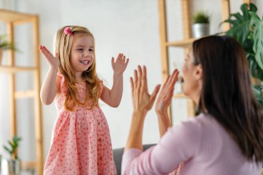 Mutlu anne ve kız oturma odasında birlikte vakit geçiriyorlar.