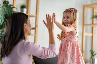Mutlu anne ve kız oturma odasında birlikte vakit geçiriyorlar.