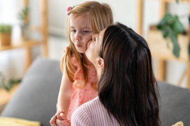 Mutlu anne ve kız oturma odasında birlikte vakit geçiriyorlar.