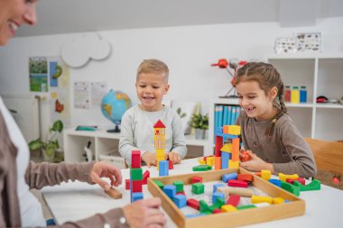 Renkli yapı taşlarıyla oynayan anaokulu çocukları. Sağlıklı öğrenme ortamı. Oynayarak öğrenmek.