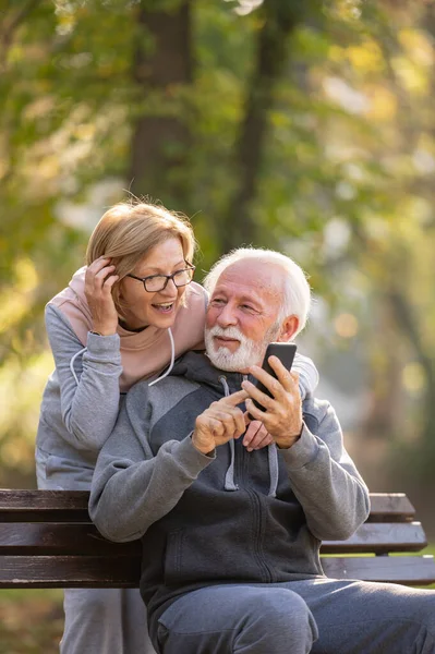 Couple Âgé Utilisant Téléphone Portable Assis Sur Banc Dans Parc — Photo