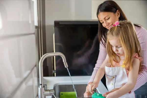 母親と娘が家事をしたり食器を洗ったり — ストック写真