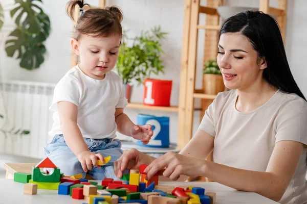 stock image mother playing with her daughter using wooden blocks