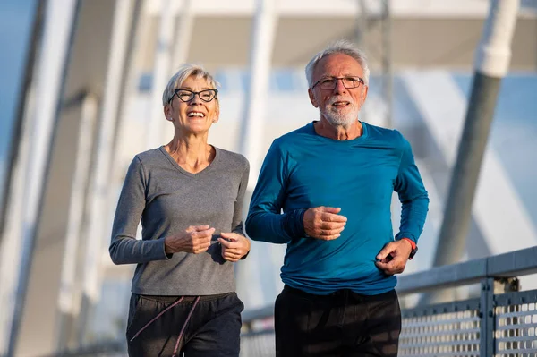 senior couple running in city