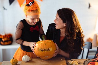 Anne ve kızı Cadılar Bayramı için balkabağı kabağı kabağı kabağı oymaya hazırlanıyor. 