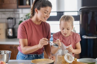 Mutlu anne ve kız mutfakta birlikte turta hazırlıyorlar.