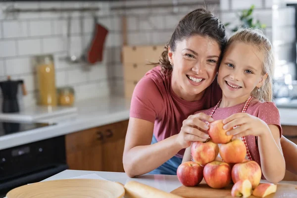 mother and daughter making pyramid with apples