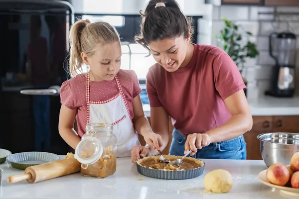 stock image happy mother and daughter preparing pie together in kitchen