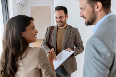 Adam ve hamile karısı, bir emlakçıyla konuşuyorlar. Satılık ya da kiralık bir daireyi ziyaret ediyorlar. Müstakbel ebeveynler daire alıyor. Emlak kavramı