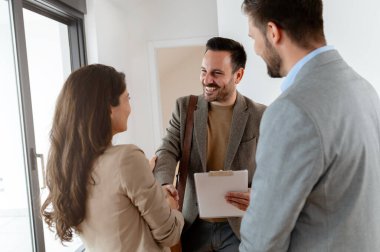 Adam ve hamile karısı, bir emlakçıyla konuşuyorlar. Satılık ya da kiralık bir daireyi ziyaret ediyorlar. Müstakbel ebeveynler daire alıyor. Emlak kavramı