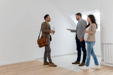 Adam ve hamile karısı, bir emlakçıyla konuşuyorlar. Satılık ya da kiralık bir daireyi ziyaret ediyorlar. Müstakbel ebeveynler daire alıyor. Emlak kavramı