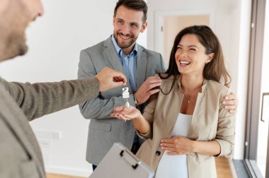 Adam ve hamile karısı, bir emlakçıyla konuşuyorlar. Satılık ya da kiralık bir daireyi ziyaret ediyorlar. Müstakbel ebeveynler daire alıyor. Emlak kavramı