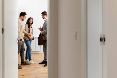 Adam ve hamile karısı, bir emlakçıyla konuşuyorlar. Satılık ya da kiralık bir daireyi ziyaret ediyorlar. Müstakbel ebeveynler daire alıyor. Emlak kavramı