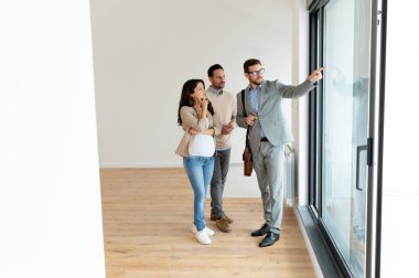 Adam ve hamile karısı, bir emlakçıyla konuşuyorlar. Satılık ya da kiralık bir daireyi ziyaret ediyorlar. Müstakbel ebeveynler daire alıyor. Emlak kavramı