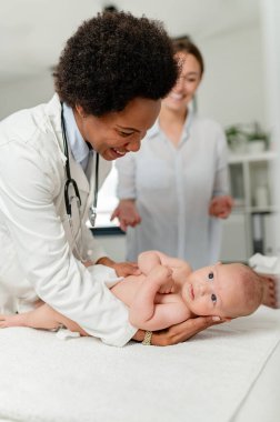 Hastanede küçük bebeği muayene eden bir çocuk doktoru.