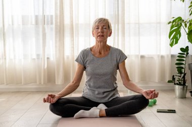 Son sınıf öğrencisi evde yoga yapıyor.