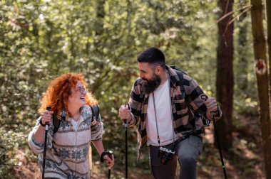 Mutlu genç çift dağlardaki orman yolunda eğleniyor, genç adam ve kadın. 