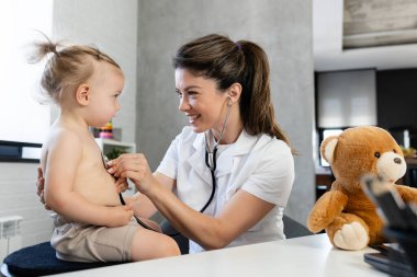 Küçük kızı muayene eden kadın doktoru kapatın. 