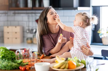 Mutlu anne ve kız kahvaltıyı evde hazırlıyorlar. 