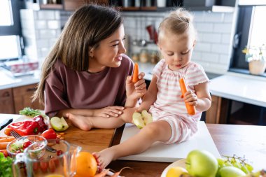 Mutfakta bebeğini besleyen mutlu genç bir anne. sağlıklı beslenme. 